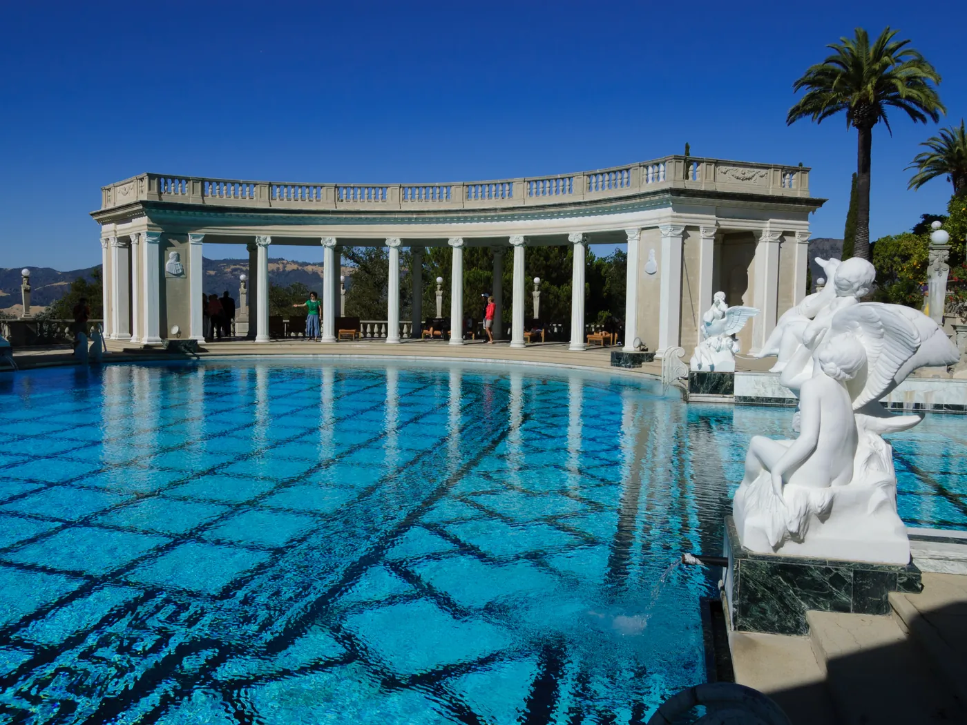A grand outdoor pool lined with columns and statues